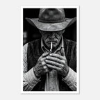 Black and white portrait of a cowboy lighting a cigarette wearing a hat, western wall art.