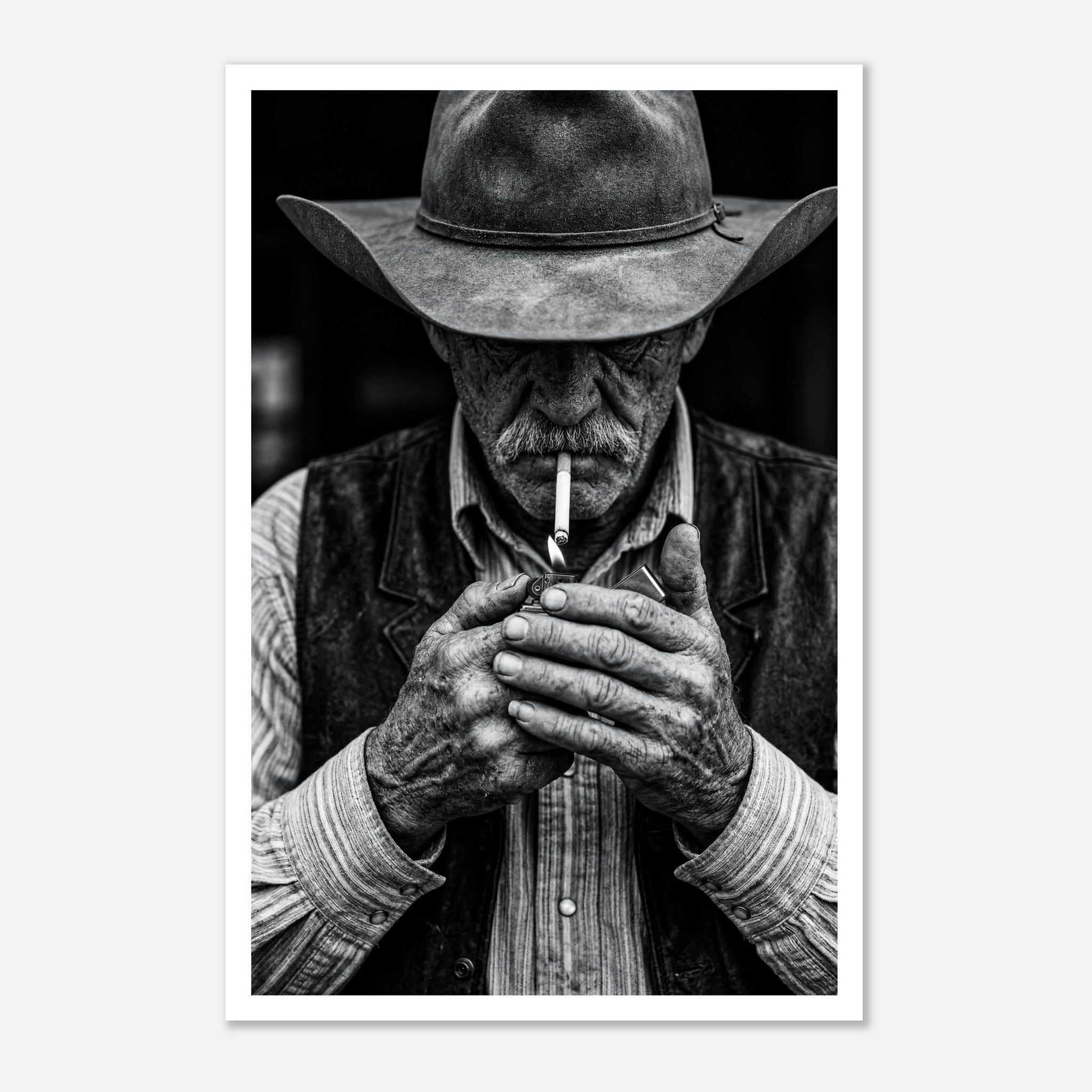 Black and white portrait of a cowboy lighting a cigarette wearing a hat, western wall art.