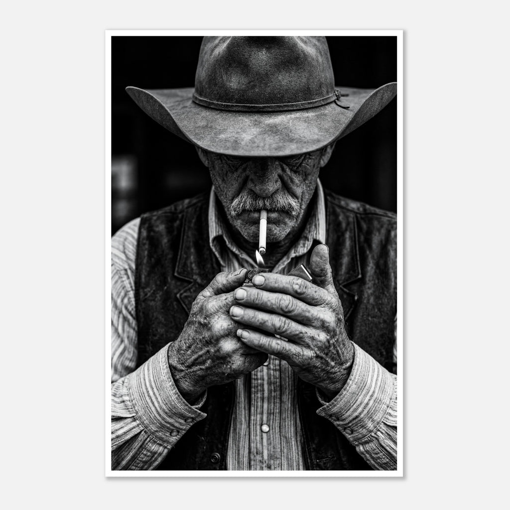 Black and white portrait of a cowboy lighting a cigarette wearing a hat, western wall art.