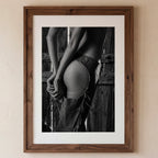 Framed black and white photograph of a person in a rustic setting.