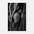 Black and white cowgirl wall art featuring fringe chaps and leather detail against rustic wood background.