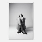 Black and white fine art poster of a seated cowgirl figure wearing classic cowboy boots against a minimalist studio background, creating a dramatic western-inspired composition.