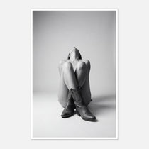 Black and white fine art poster of a seated cowgirl figure wearing classic cowboy boots against a minimalist studio background, creating a dramatic western-inspired composition.