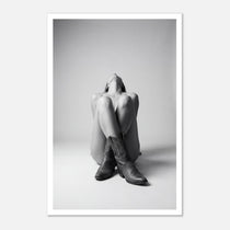 Black and white fine art poster of a seated cowgirl figure wearing classic cowboy boots against a minimalist studio background, creating a dramatic western-inspired composition.