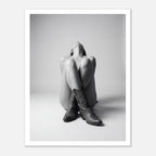 Black and white fine art poster of a seated cowgirl figure wearing classic cowboy boots against a minimalist studio background, creating a dramatic western-inspired composition.