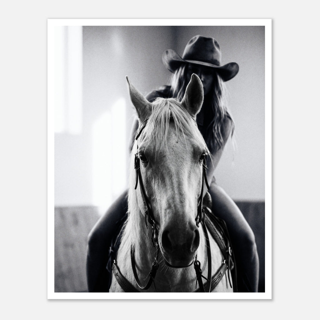Black and white photograph of a cowgirl riding a horse head on wearing a cowboy hat, western equestrian wall art.