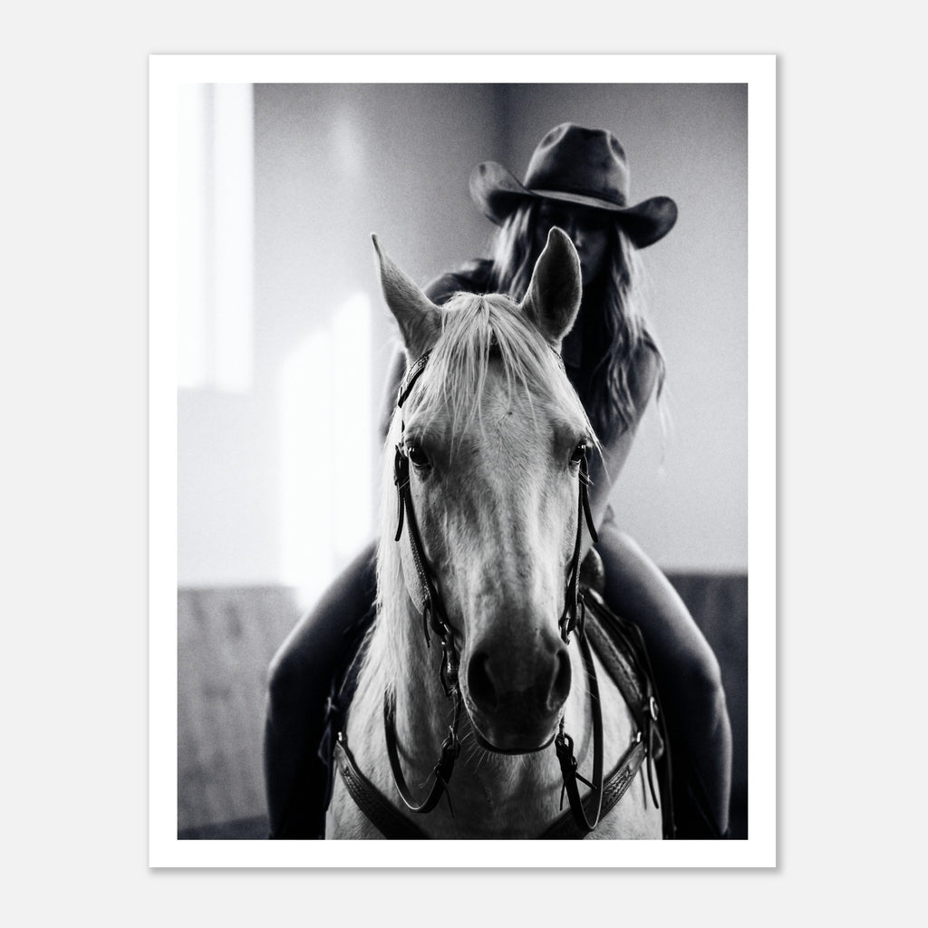 Black and white photograph of a cowgirl riding a horse head on wearing a cowboy hat, western equestrian wall art.