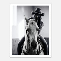 Black and white photograph of a cowgirl riding a horse head on wearing a cowboy hat, western equestrian wall art.