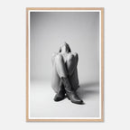 Framed black and white art print of a person sitting with cowboy boots on a plain background