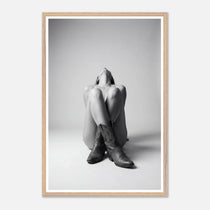 Framed black and white art print of a person sitting with cowboy boots on a plain background
