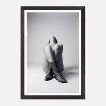 Framed black and white photo of a person sitting with legs crossed wearing cowboy boots.