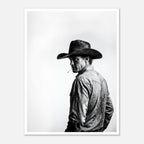 Black and white photograph of a rodeo cowboy wearing a western hat and cigarette, turning toward the camera after competition, western cowboy wall art poster.