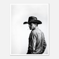 Black and white photograph of a rodeo cowboy wearing a western hat and cigarette, turning toward the camera after competition, western cowboy wall art poster.