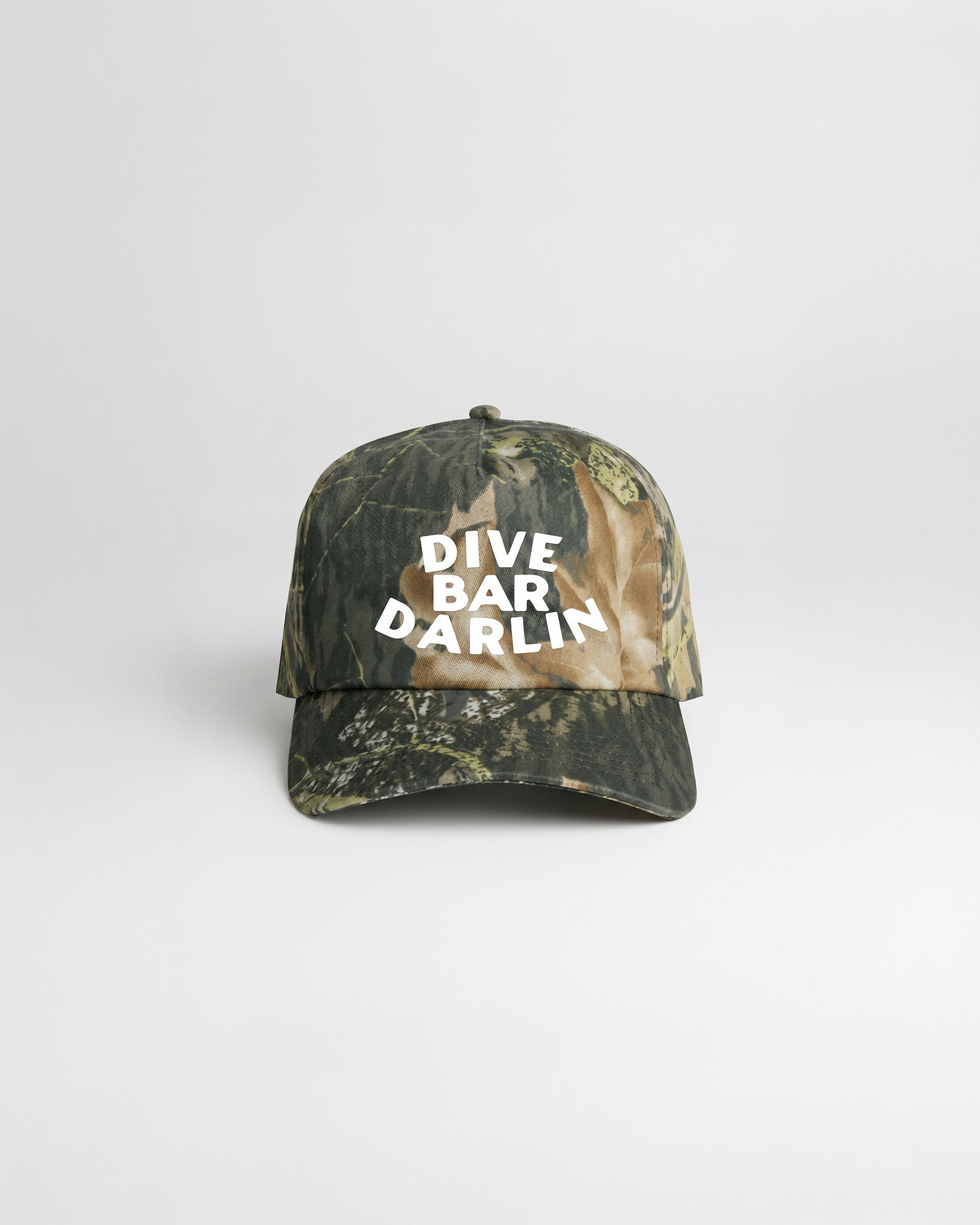 Dive Bar Darlin camo snapback cap with curved peak and bold white lettering on front panel