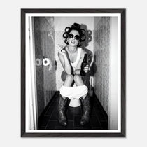 Black and white photograph of a rebellious cowgirl wearing cowboy boots and sunglasses sitting in a tiled restroom holding a cigarette and beer.