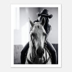 Black and white photograph of a cowgirl riding a horse head on wearing a cowboy hat, western equestrian wall art.