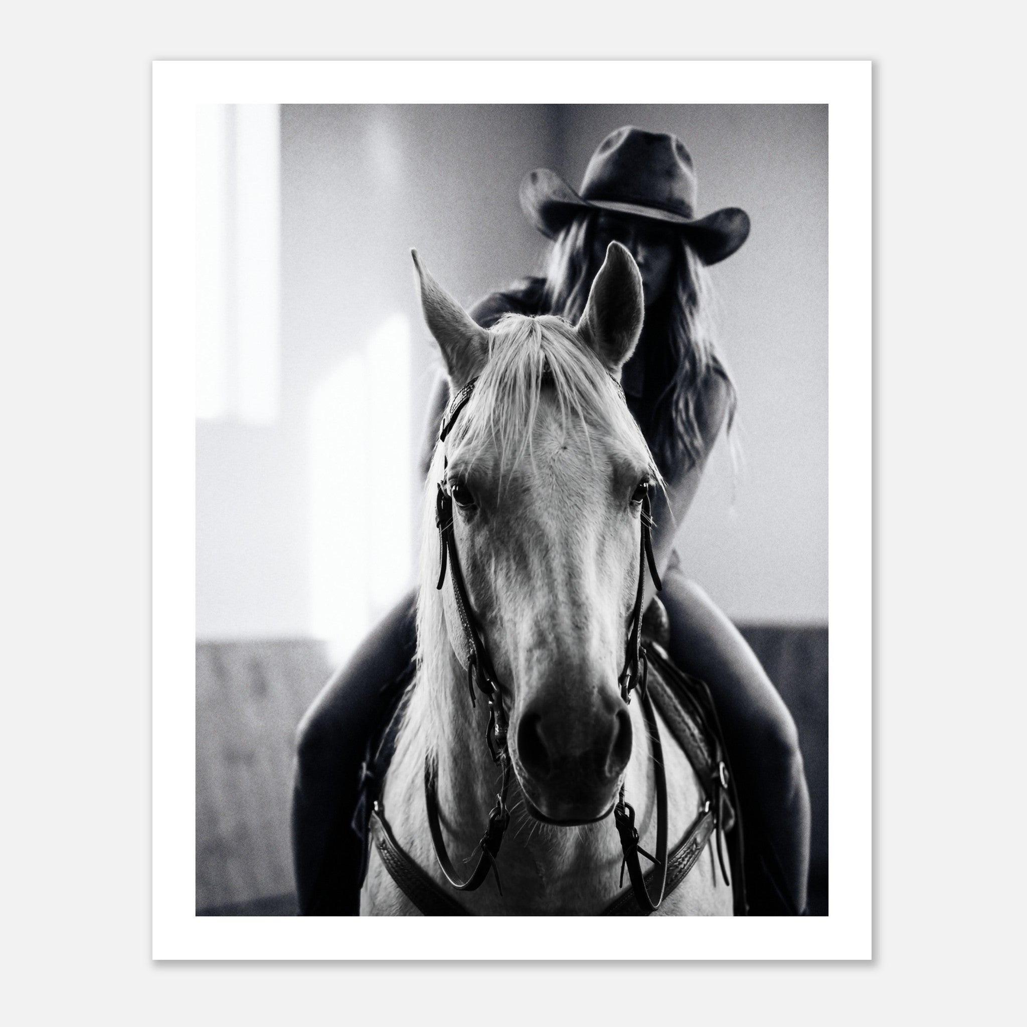 Black and white photograph of a cowgirl riding a horse head on wearing a cowboy hat, western equestrian wall art.
