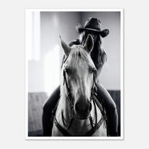 Black and white photograph of a cowgirl riding a horse head on wearing a cowboy hat, western equestrian wall art.