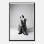 Framed black and white art print of a person sitting with cowboy boots on a plain background
