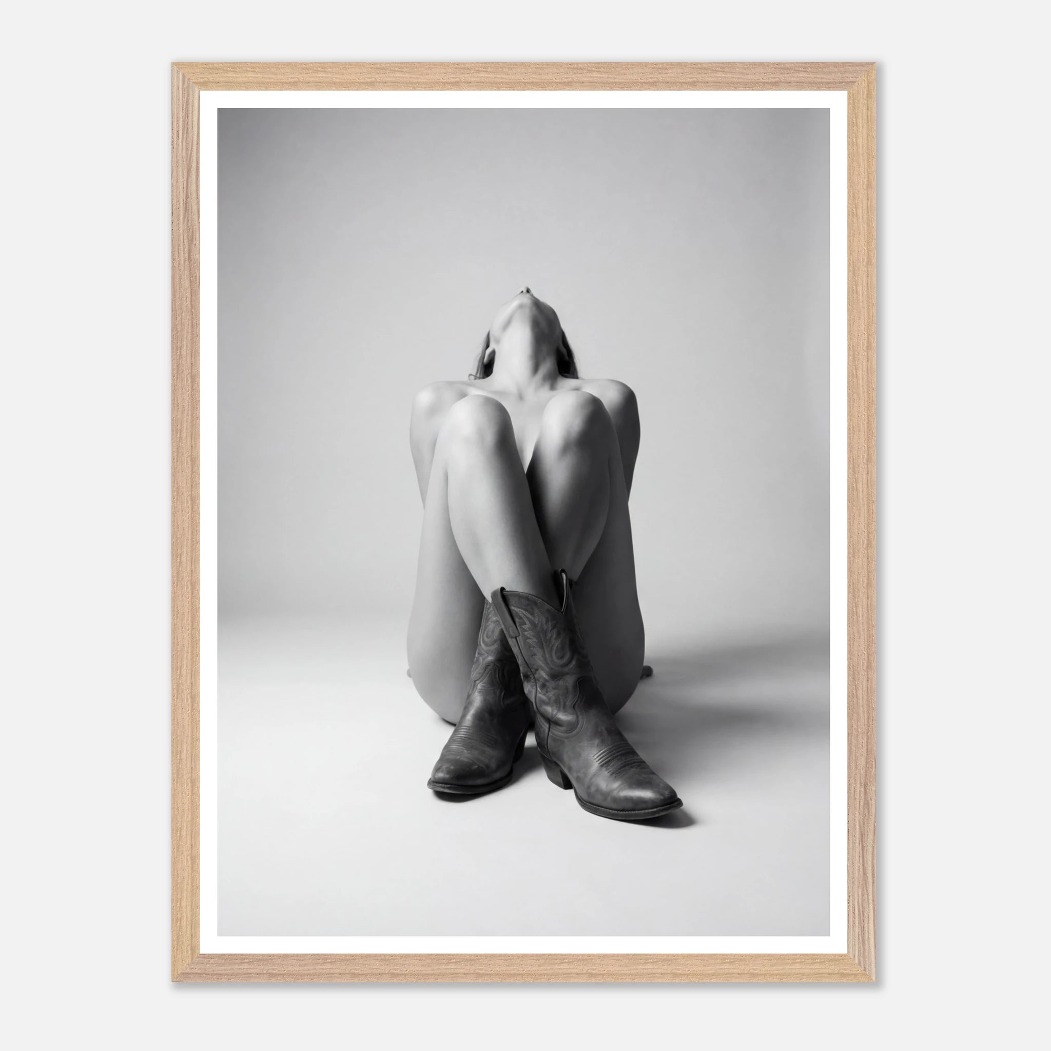 Framed black and white art print of a person wearing cowboy boots on a light gray background.