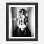 Black and white photograph of a rebellious cowgirl wearing cowboy boots and sunglasses sitting in a tiled restroom holding a cigarette and beer.