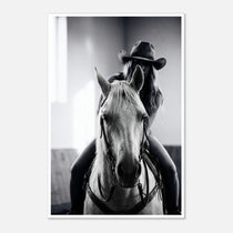 Black and white photograph of a cowgirl riding a horse head on wearing a cowboy hat, western equestrian wall art.