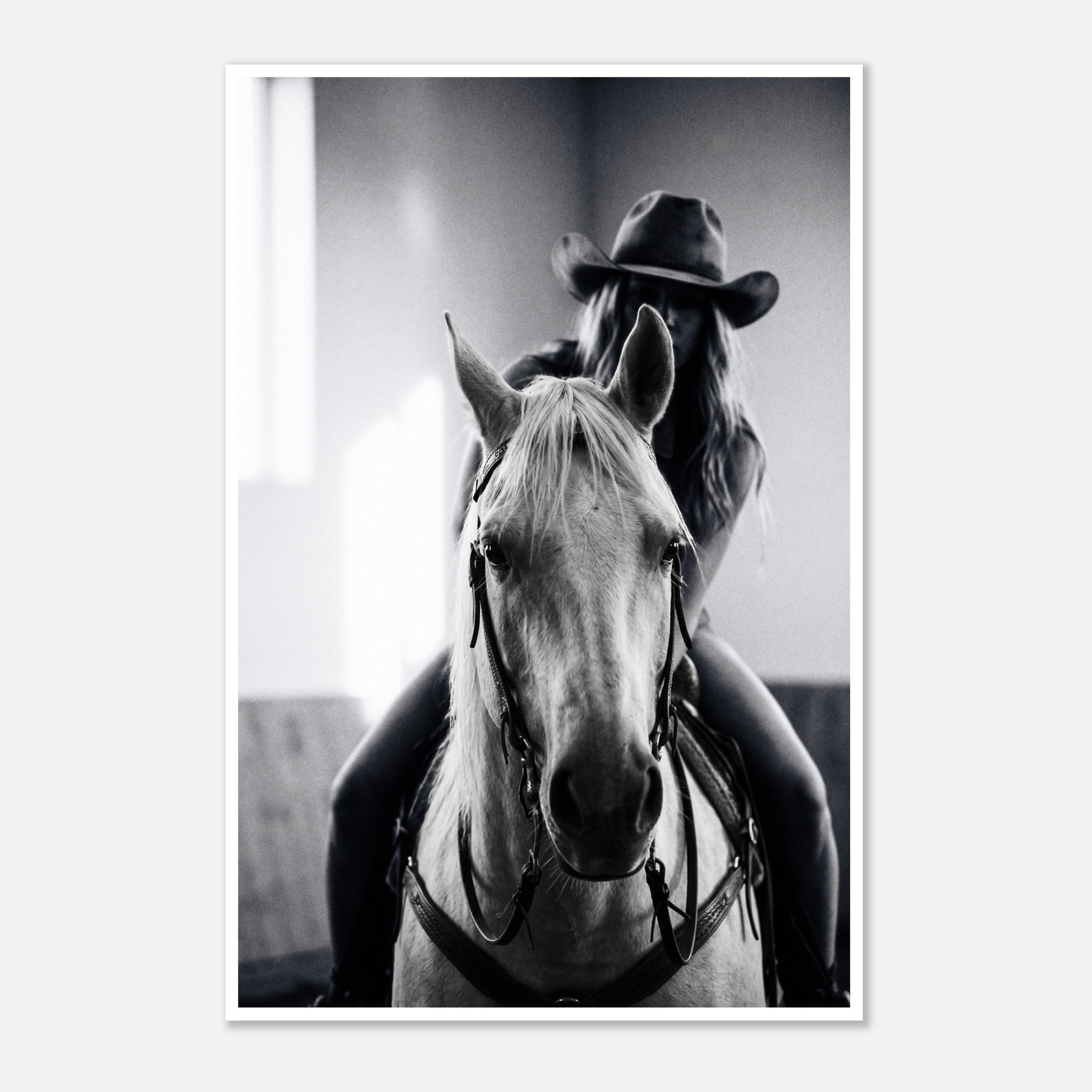 Black and white photograph of a cowgirl riding a horse head on wearing a cowboy hat, western equestrian wall art.