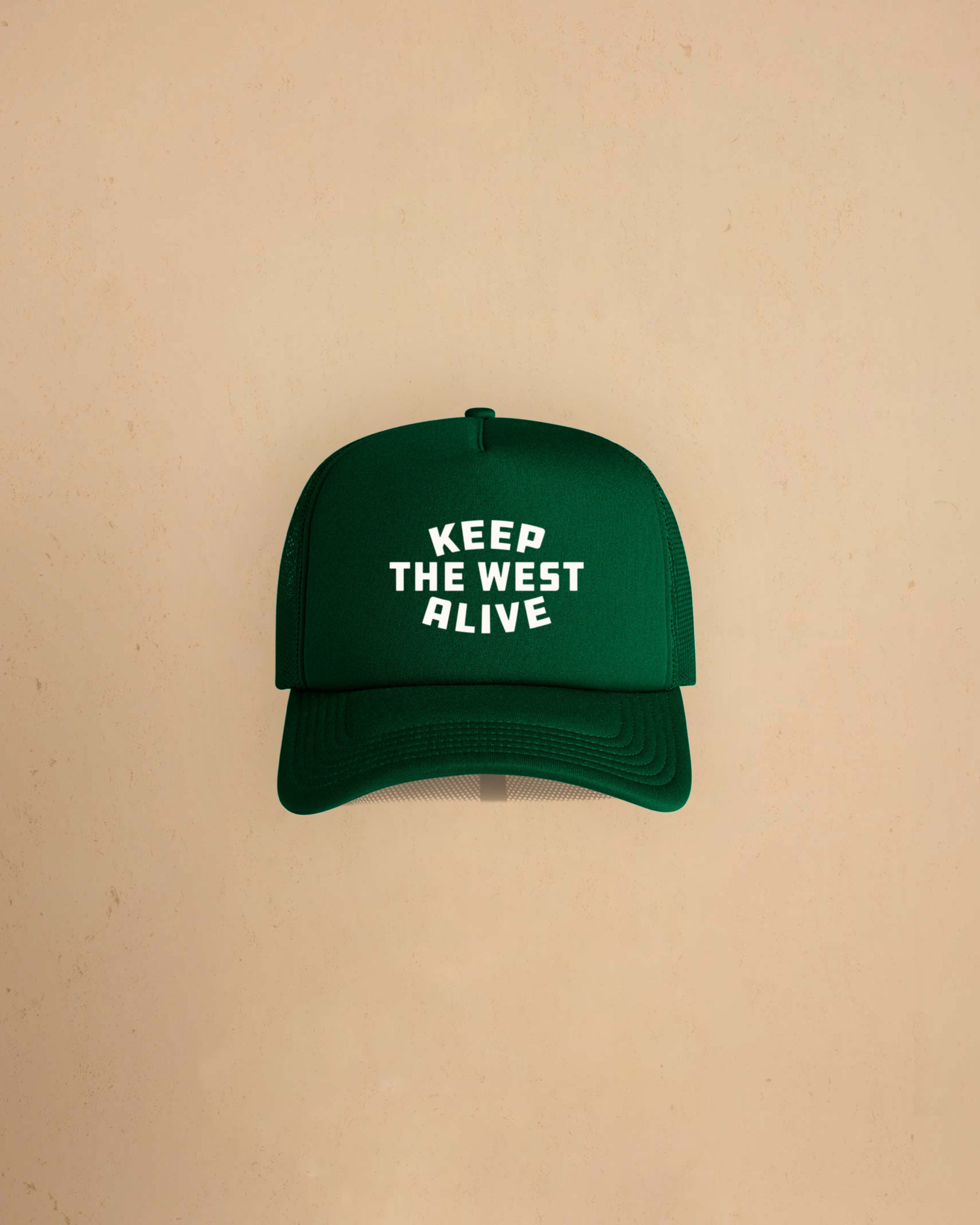 High-profile trucker cap featuring “Keep The West Alive” western typography on the front with mesh back and curved peak.