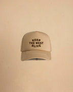 High-profile trucker cap featuring “Keep The West Alive” western typography on the front with mesh back and curved peak.
