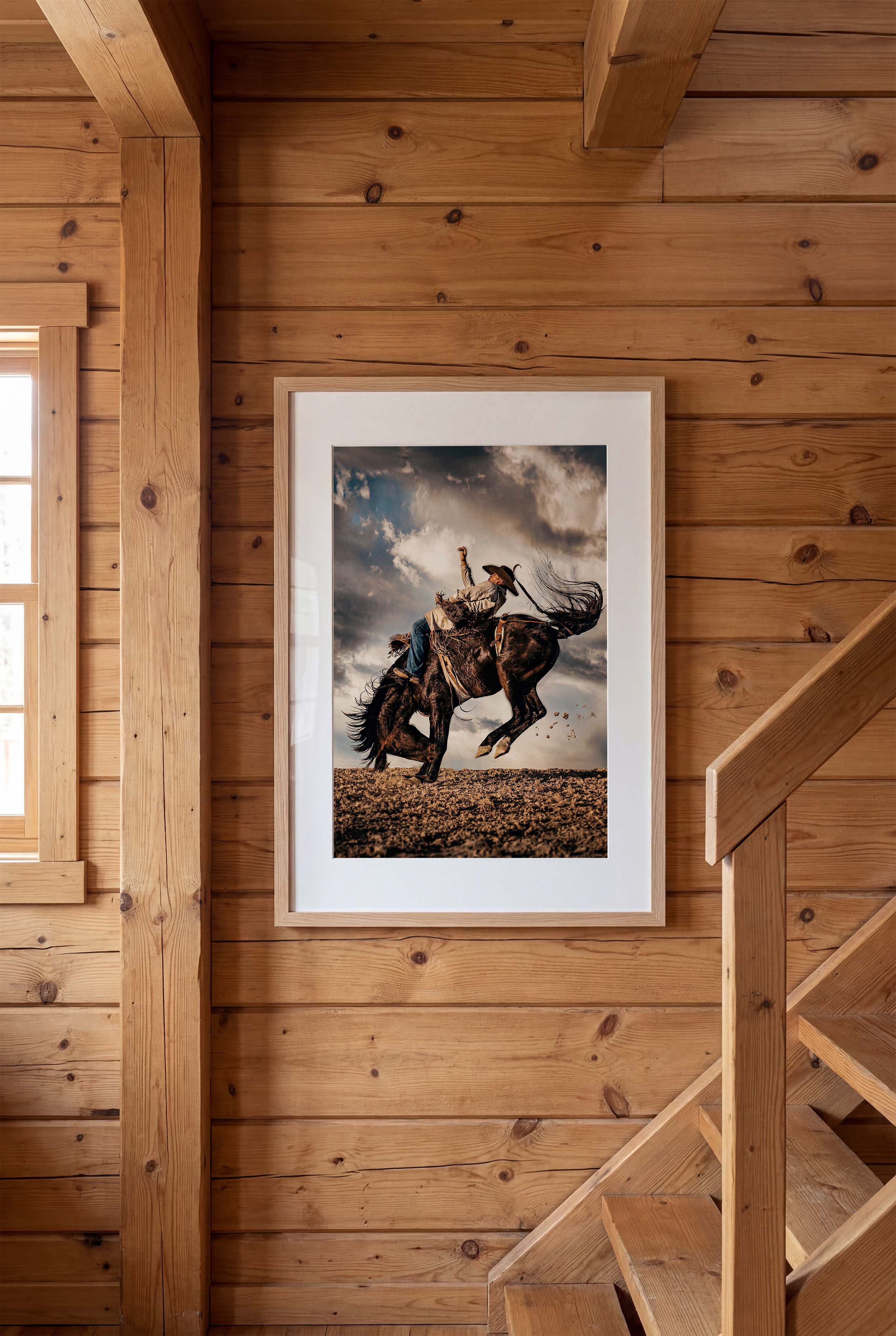 Framed picture of a person riding a horse on a wooden wall.