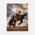 Cowboy riding a bucking horse at sunset with dust and dramatic sky, western rodeo wall art print