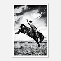 Black and white rodeo wall art showing a cowboy riding a bucking horse in motion.