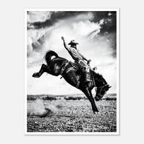 Black and white rodeo wall art showing a cowboy riding a bucking horse in motion.