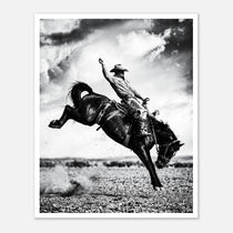 Black and white rodeo wall art showing a cowboy riding a bucking horse in motion.