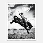 Black and white rodeo wall art showing a cowboy riding a bucking horse in motion.