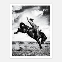 Black and white rodeo wall art showing a cowboy riding a bucking horse in motion.