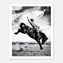 Black and white rodeo wall art showing a cowboy riding a bucking horse in motion.