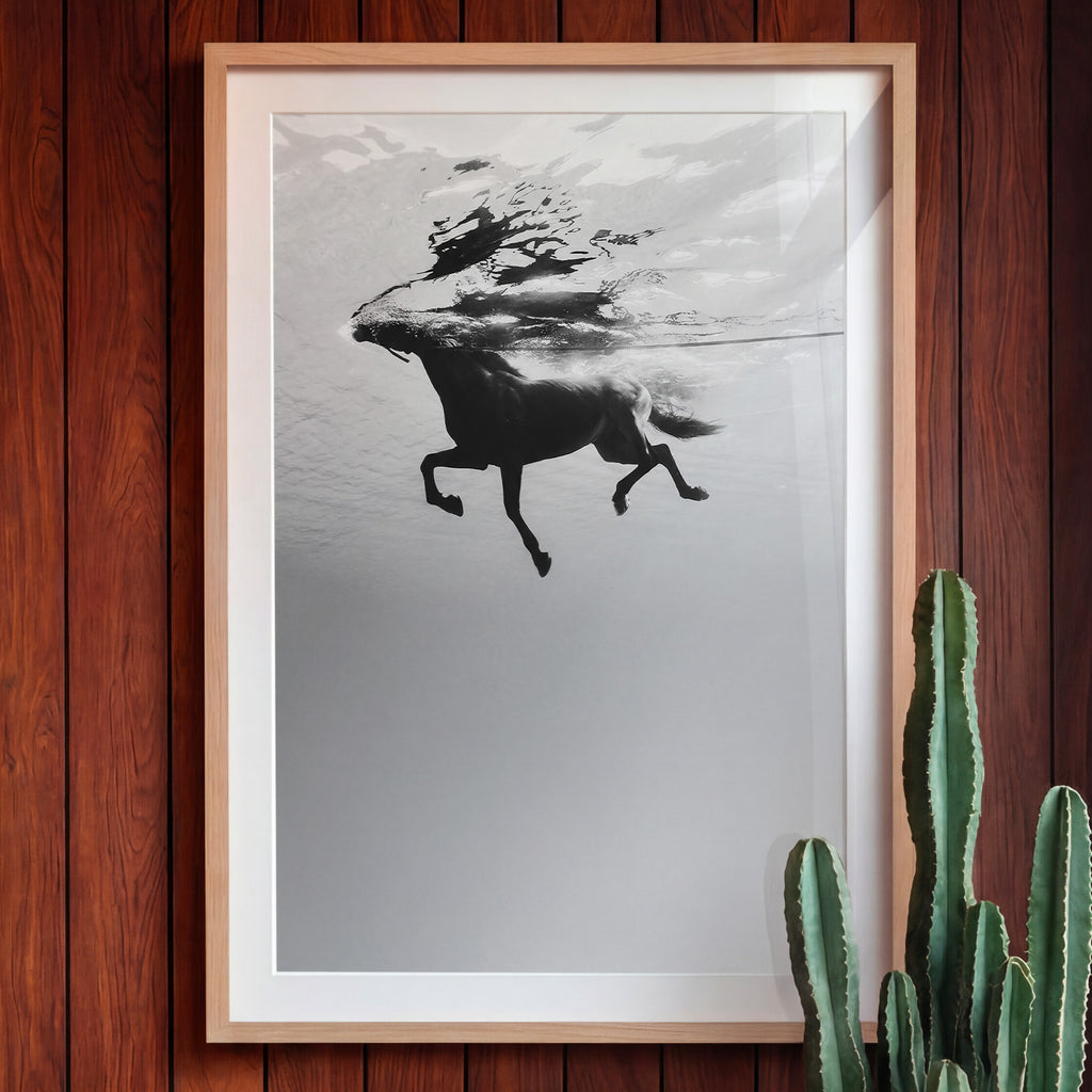 Framed artwork of a horse underwater on a wooden wall with a cactus plant.