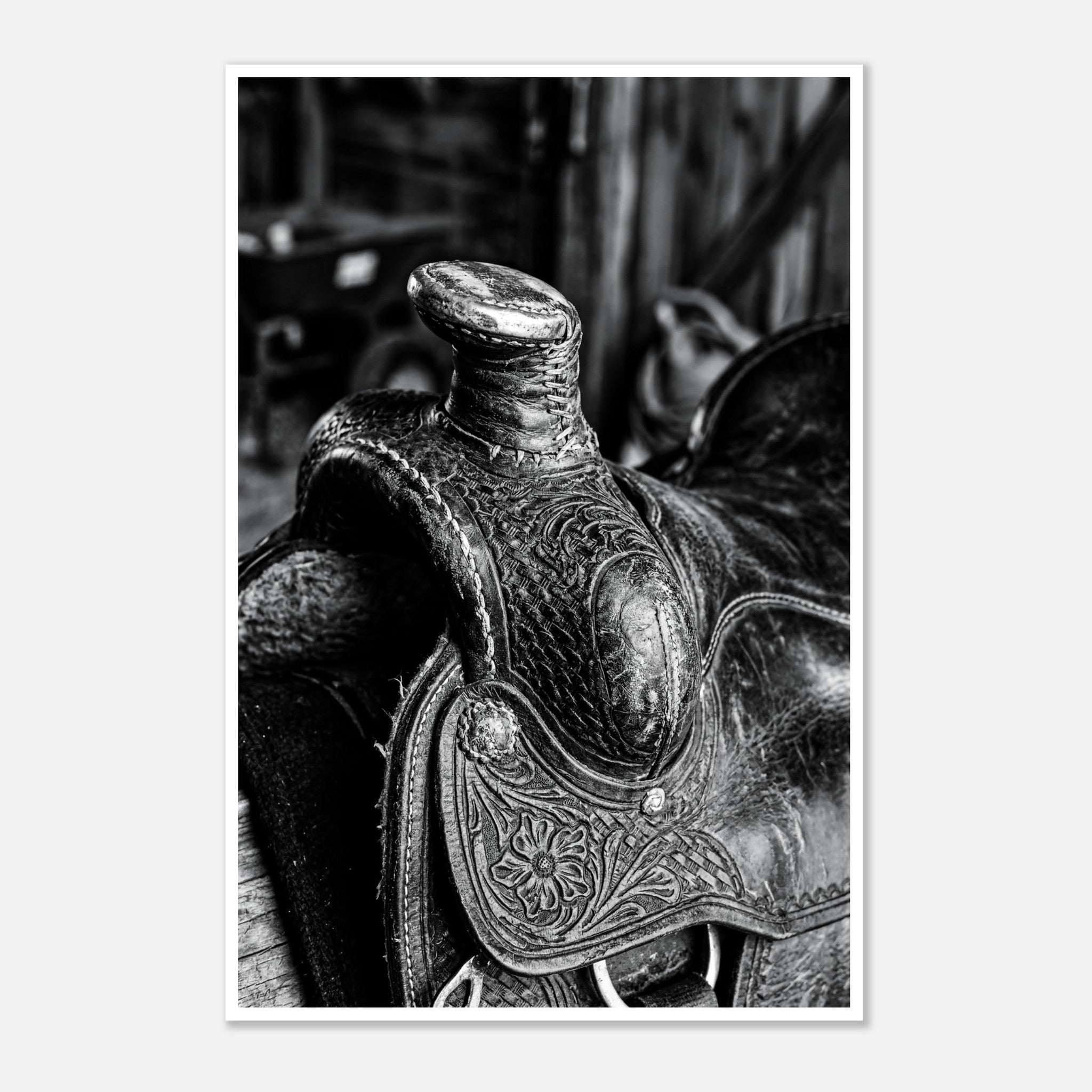 Black and white close up of a western saddle with worn leather and detailed craftsmanship, ranch wall art.