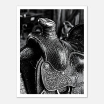 Black and white close up of a western saddle with worn leather and detailed craftsmanship, ranch wall art.
