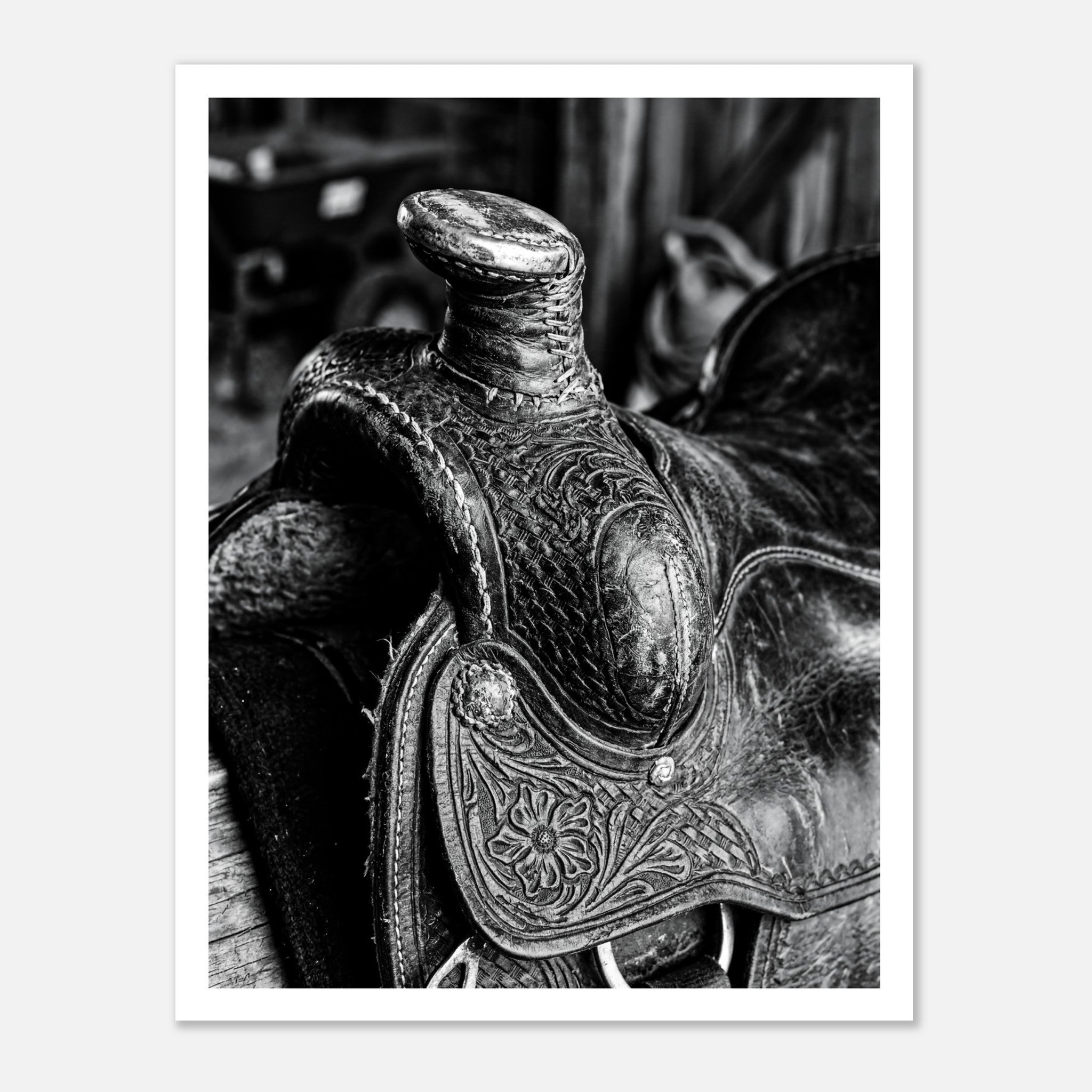 Black and white close up of a western saddle with worn leather and detailed craftsmanship, ranch wall art.