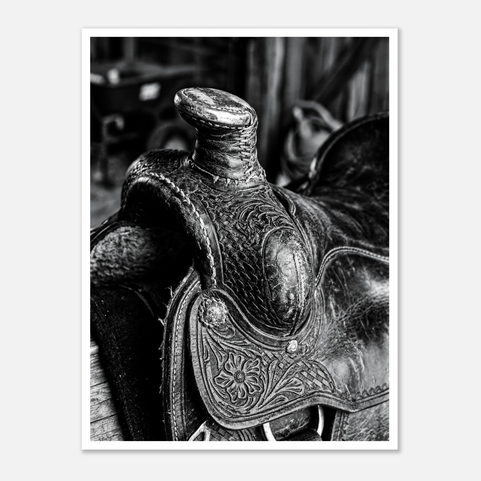 Black and white close up of a western saddle with worn leather and detailed craftsmanship, ranch wall art.