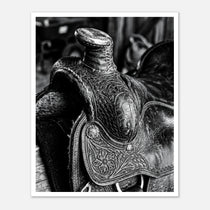 Black and white close up of a western saddle with worn leather and detailed craftsmanship, ranch wall art.