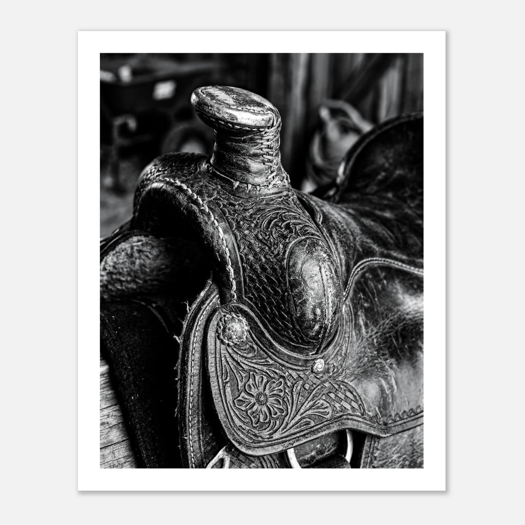 Black and white close up of a western saddle with worn leather and detailed craftsmanship, ranch wall art.