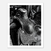 Black and white close up of a western saddle with worn leather and detailed craftsmanship, ranch wall art.