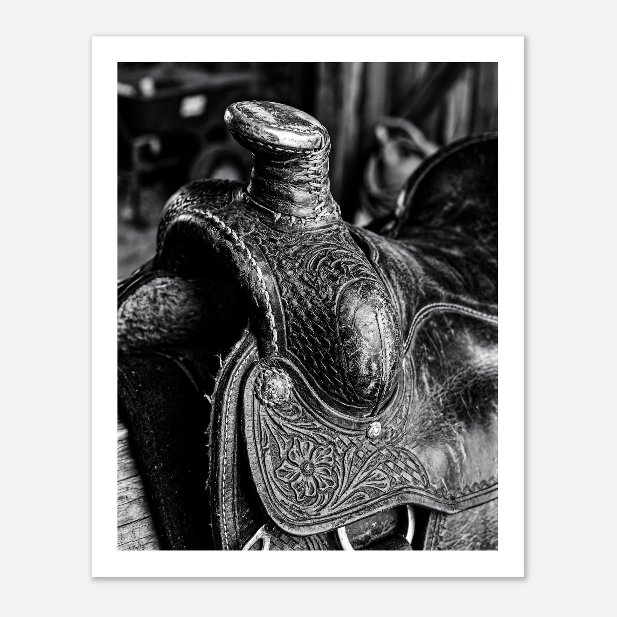 Black and white close up of a western saddle with worn leather and detailed craftsmanship, ranch wall art.