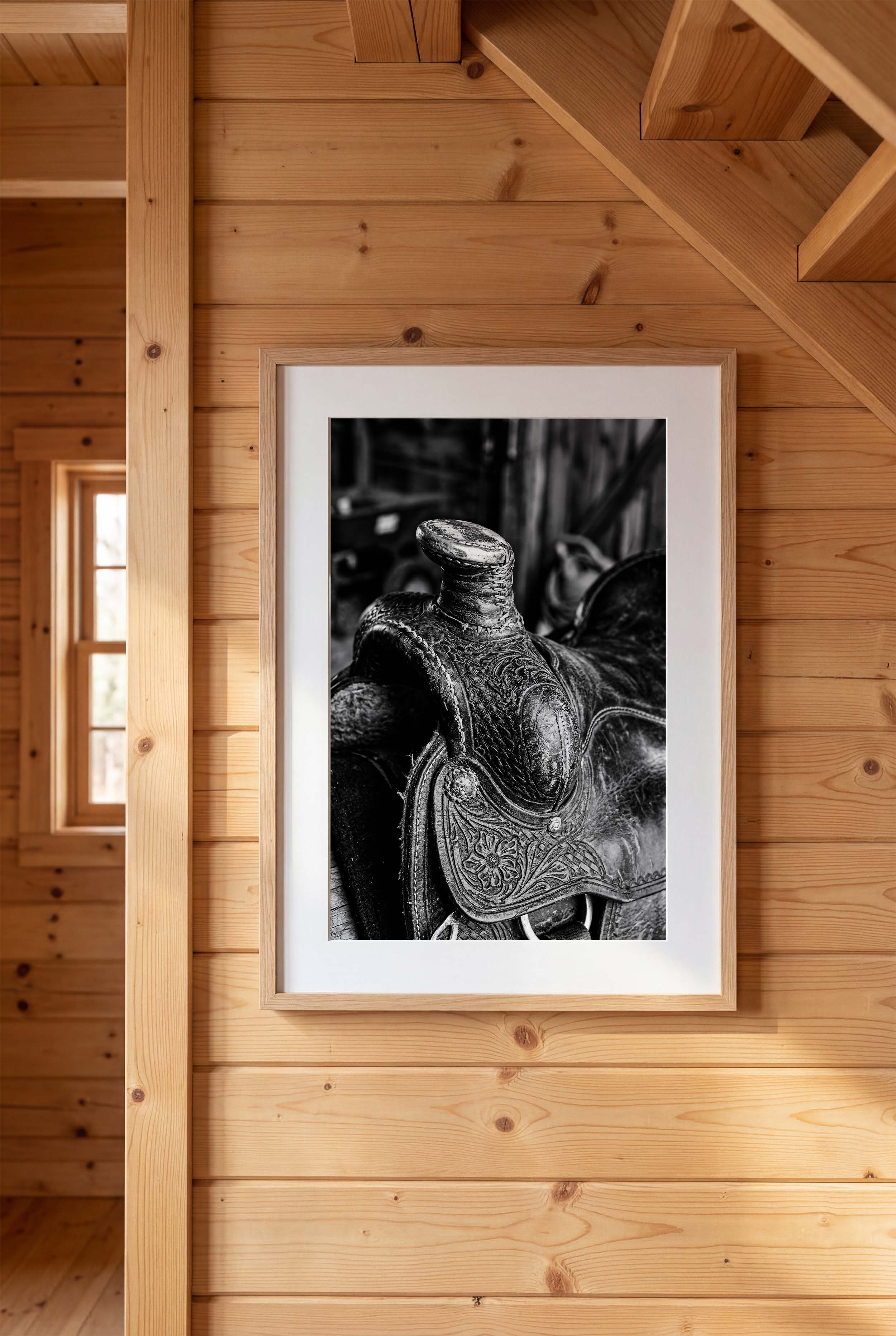 Black and white close up of a western saddle with worn leather and detailed craftsmanship, ranch wall art.