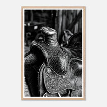 Black and white close up of a western saddle with worn leather and detailed craftsmanship, ranch wall art.
