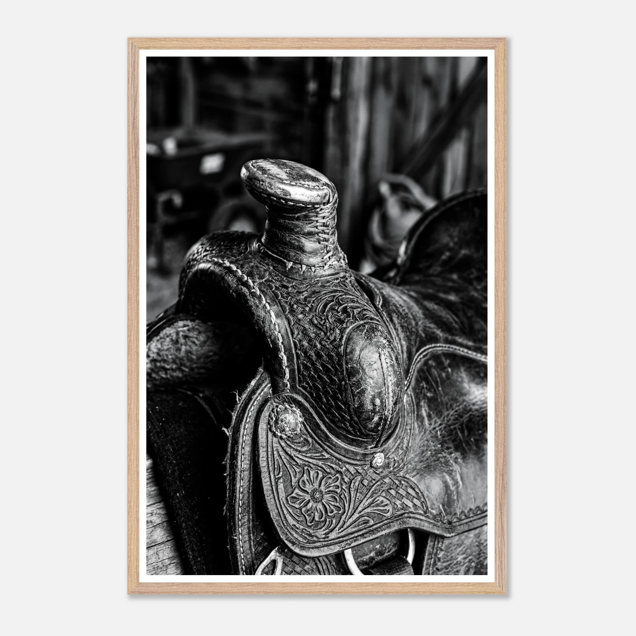 Black and white close up of a western saddle with worn leather and detailed craftsmanship, ranch wall art.