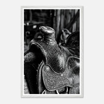 Black and white close up of a western saddle with worn leather and detailed craftsmanship, ranch wall art.